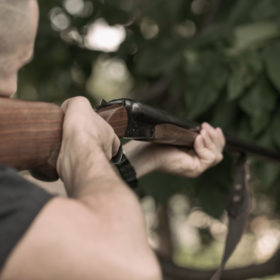 Man charging double-barreled hunting rifle closeup